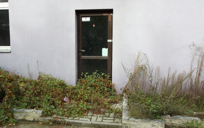 Drzwi do lokalu przy ulicy Kolejowej zarastają chmielem