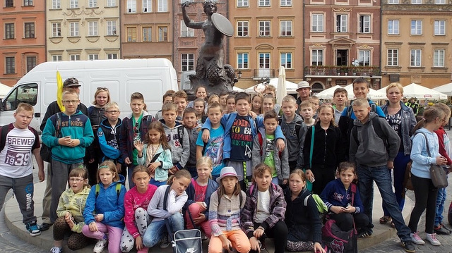 Uczniowie z opiekunami pod pomnikiem Syrenki na warszawskiej Starówce