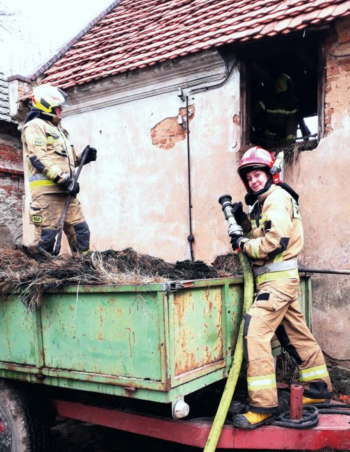 Weronika Kliś w mundurze Państwowej Straży Pożarnej podczas gaszenia pożaru pomieszczenia gospodarczego w Kuropatniku