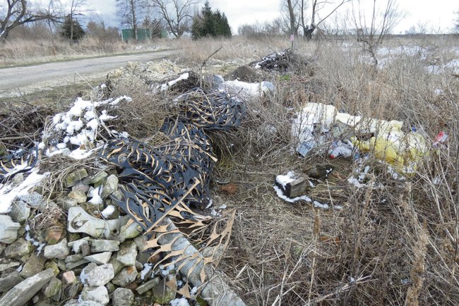 Wśród wyrzuconych przy drodze śmieci jest gruz, asfalt, są plastiki i gumowe maty po produkcji obuwia