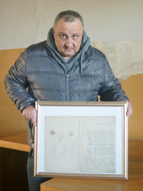 Pan Grzegorz z dumą prezentuje najcenniejszy dokument w swojej kolekcji