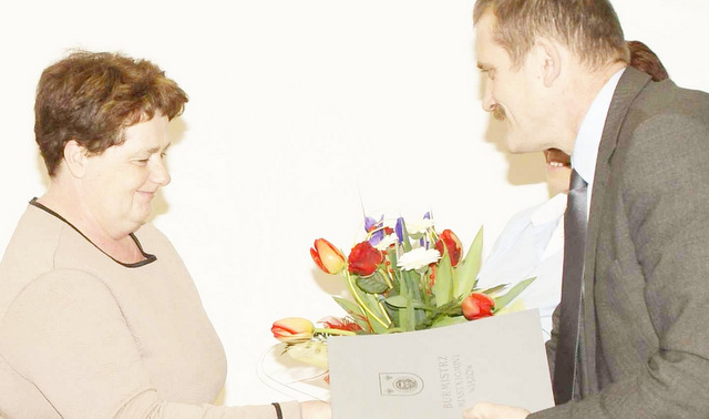 Burmistrz Krochmalny wręczył bukiet kwiatów Halinie Olszówce, nowej sołtys Michałowic Oławskich, w głębi Elżbieta Mossoń