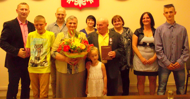 Państwo Kossowie z rodziną i sekretarzem gminy podczas uroczystości Złotych Godów